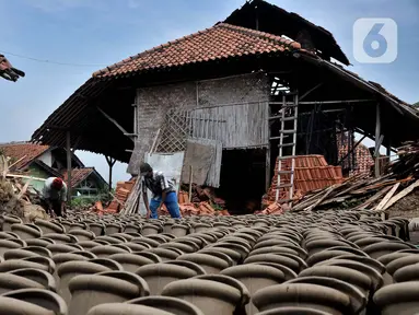 Pekerja menjemur genteng di pabrik genteng rumahan (Jebor) Mutiara Putra, Desa Burujul Wetan, Kecamatan Jatiwangi, Kabupaten Majalengka, Minggu (30/1/2022). Sejak tahun 70-an, Kecamatan Jatiwangi terkenal dengan sentra genteng yang hasil produksinya kualitas terbaik. (merdeka.com/Iqbal S. Nugroho)