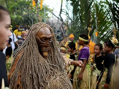 Seorang anggota dari adat Mah Meri mengenakan kostum dan topeng saat ritual Puja Pantai di Pulau Carey, Malaysia (2/1). Mereka adalah orang asli yang mendiami Pulau Carey dan merupakan salah satu etnik Malaysia yang masih ada. (AFP/Manan Vatsyayana)