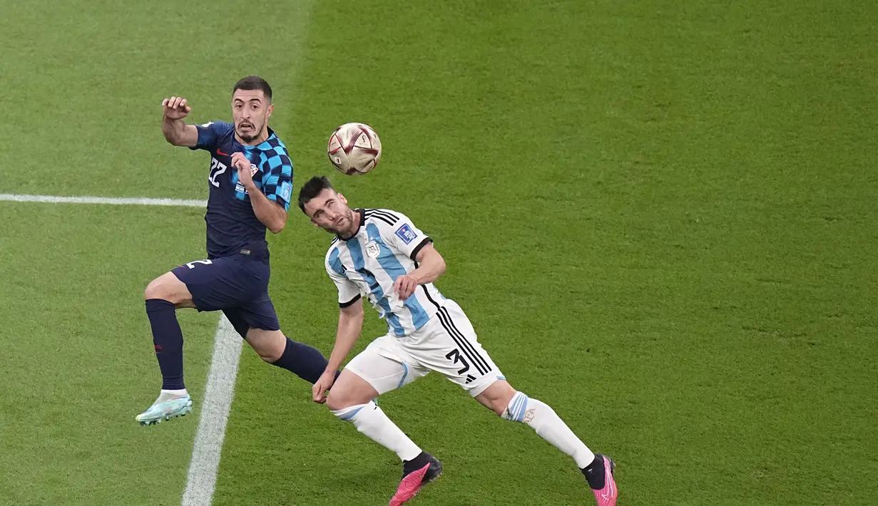 Bek Argentina, Nicolas Tagliafico berduel memperebutkan bola dengan bek Kroasia, Josip Juranovic selama pertandingan semifinal Piala Dunia 2022 di Stadion Lusail di Lusail, Qatar, Rabu (14/12/2022). Argentina berhasil lolos ke final setelah menang telak atas Kroasia dengan skor 3-0. (AP Photo/Pavel Golovkin)