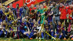 Para pemain Barcelona berpose dengan trofi Copa del Rey setelah memenangkan pertandingan melawan Sevilla pada babak final di stadion Wanda Metropolitano di Madrid, Spanyol (21/4). Barcelona menang telak 5-0. (AP Photo / Paul White)