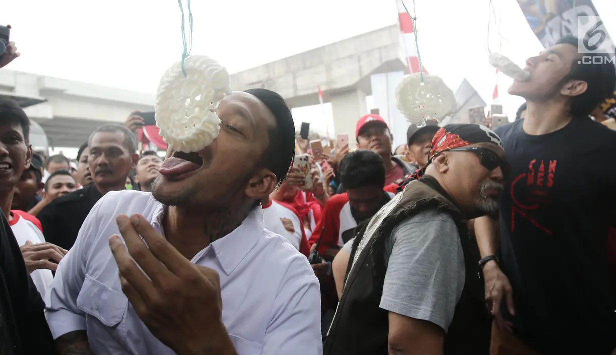 Aktor Tora Sudiro, Vino G Bastian dan Indro Warkop mengikuti lomba makan kerupuk pada Festival Kalimalang di Jakarta, Kamis (17/8). Mereka menghadiri festival Kalimalang dalam rangka promo film Warkop DKI: Reborn Part 2. (Liputan6.com/Herman Zakharia)