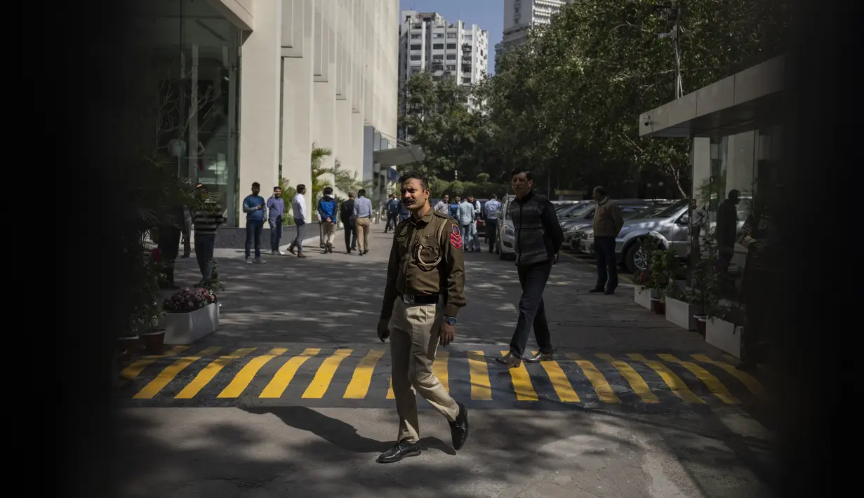<p>Seorang petugas polisi terlihat di gerbang sebuah gedung yang menampung kantor BBC di New Delhi, India, Selasa (14/2/2023). Otoritas pajak India melakukan penggeledahan kantor BBC di New Delhi, kata seorang jurnalis di lembaga penyiaran itu kepada AFP, beberapa minggu setelah menayangkan film dokumenter yang mengkritik Perdana Menteri Narendra Modi. (AP Photo/Altaf Qadri)</p>