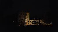 Bangunan-bangunan diterangi oleh lampu mobil saat melewati sebuah jalan di Kharkiv, Ukraina, Minggu (11/9/2022). Kota itu tampaknya berada di bawah pemadaman total tanpa cahaya yang terlihat di kota di mana api akibat serangan roket Rusia mengamuk di pembangkit listrik. (AP Photo/Leo Correa)