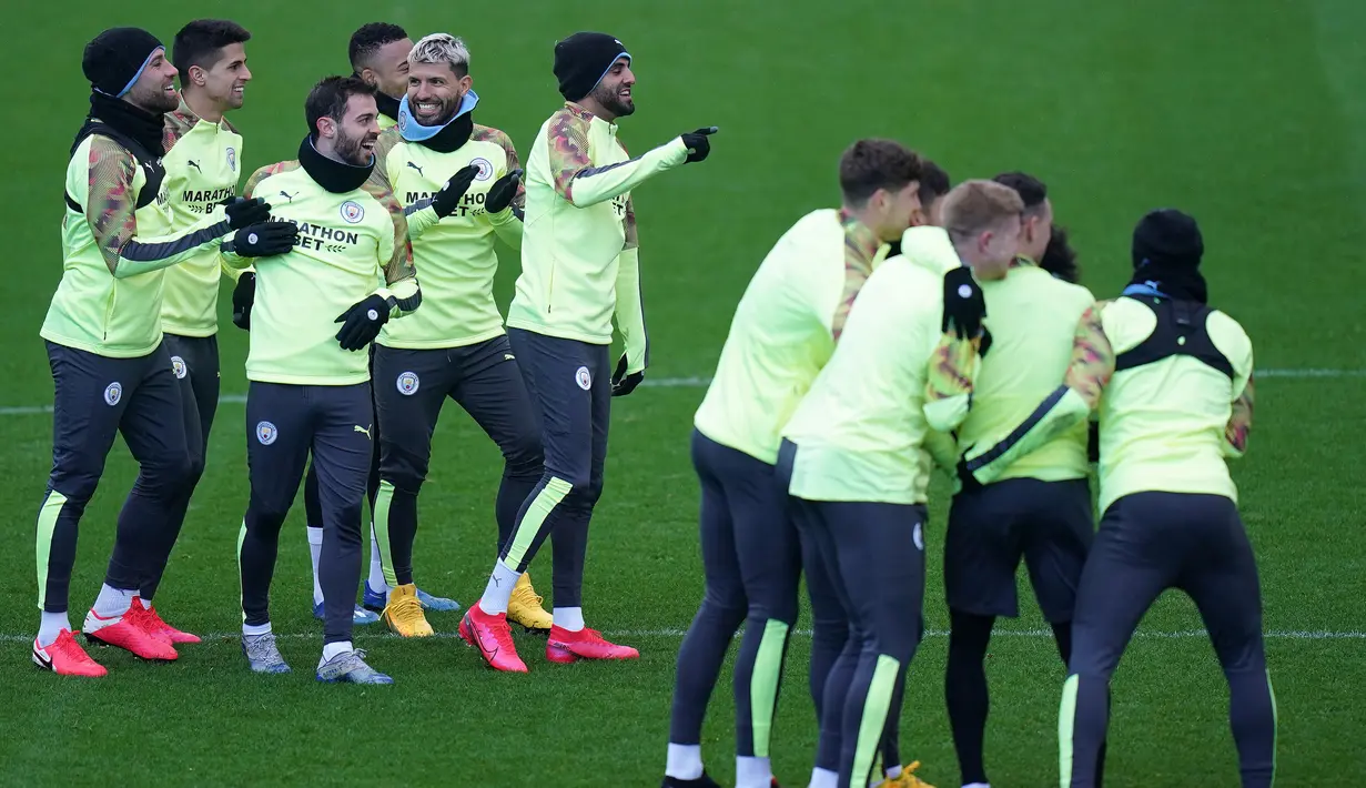 Para pemain Manchester City bercanda selama melakukan pemanasan selama sesi pelatihan tim di City Football Academy di Manchester, Inggris barat laut (25/2/2020). City akan bertanding melawan Real Madrid pada leg pertama babak 16 Liga Champions di Bernabeu. (AFP Photo/Jon Super)