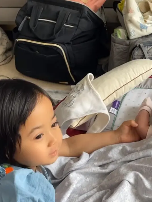 Mulai dari mengganti popok, memakaikan sarung tangan, diperhatikan seksama kedua anak Caca Tengker. (Liputan6.com/IG/@rieta_amilia)