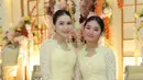 Wajahnya dipulas serba pink dari blush on hingga lipstik nude pink. Rambutnya ditata sanggul modern bagian depan belah dua tanpa aksesori. [@ayutingting92]