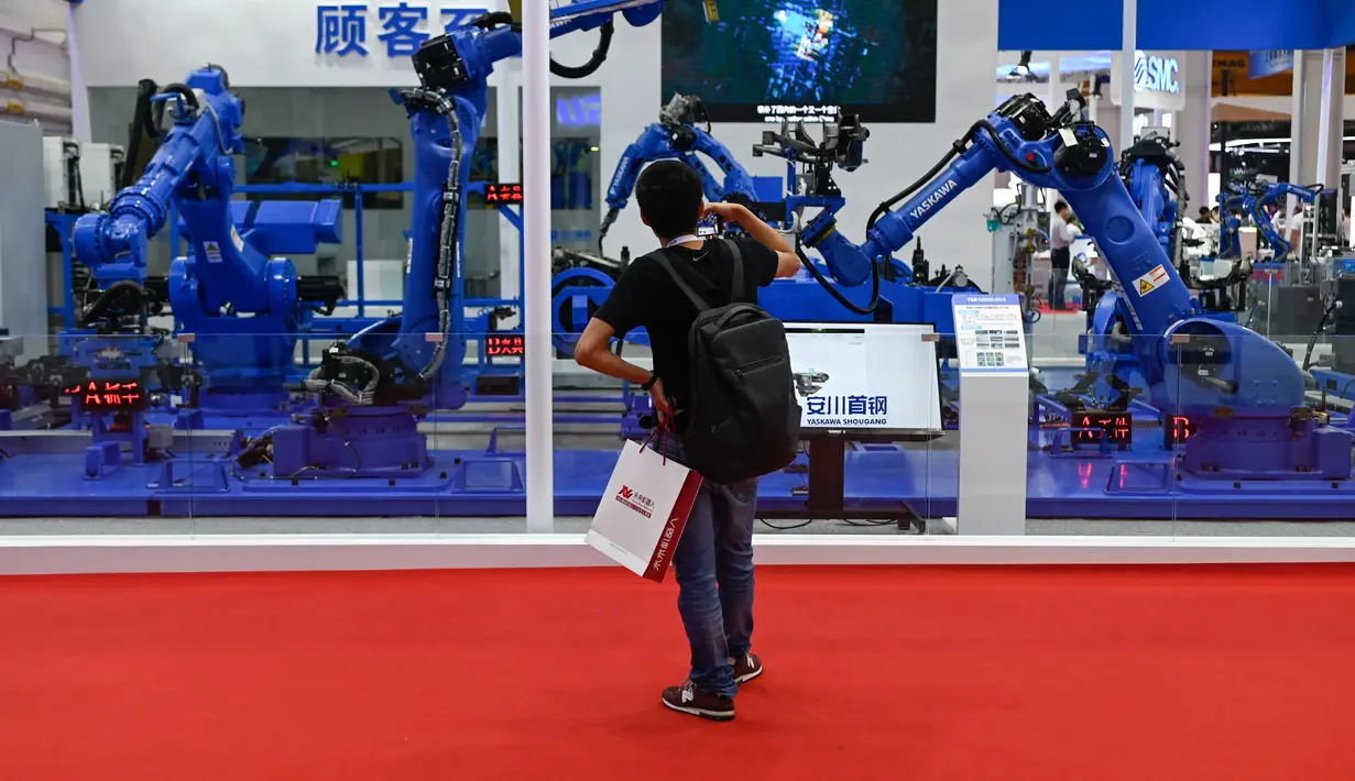 Seorang pengunjung melihat lengan robot dalam Konferensi Robot Dunia 2019 di Beijing, China, Selasa (20/8/2019). (WANG Zhao/AFP)