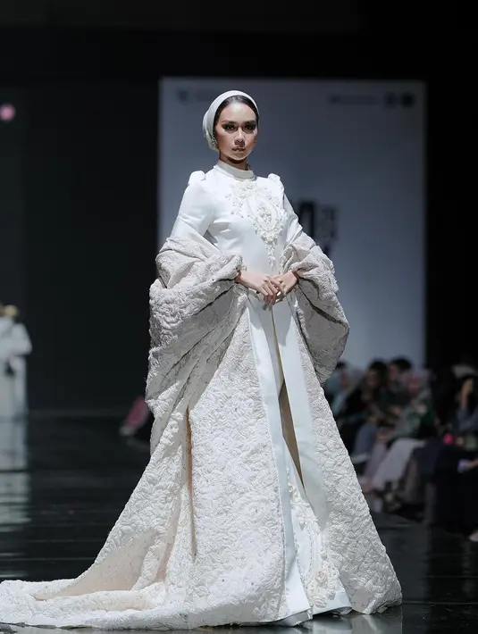 Yasinta Aurellia tampil glamor bak princess dengan gaun putih embroidery. Kesan megah semakin terlihat dengan outfit full bordir yang menawan [@officialputeriindonesia]