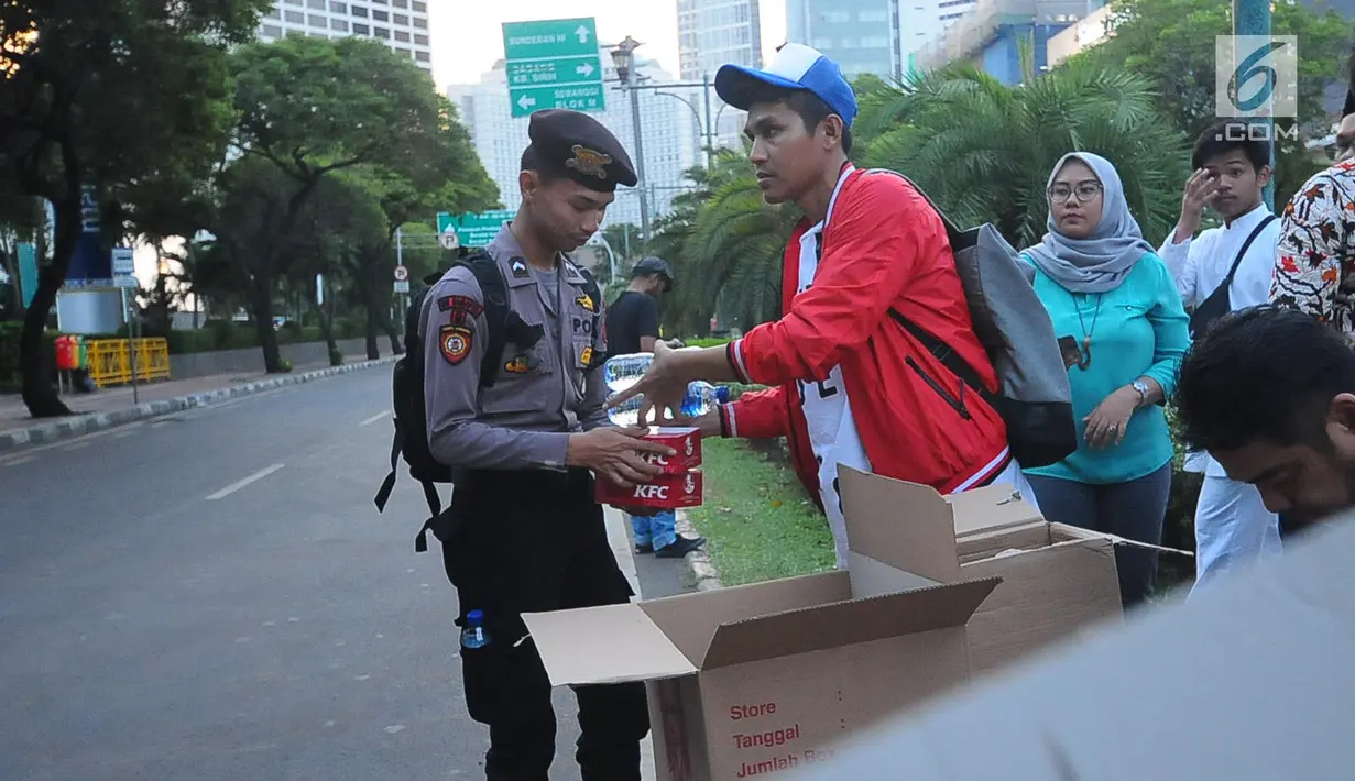 Relawan GOJO (Golkar Jokowi) memberikan makanan berbuka kepada para aparat yang melakukan penjagaan gedung KPU, Menteng, Jakarta Pusat, Kamis (23/5/). Makanan berbuka puasa ini diberikan sebagai bantuan kepada para aparat yang telah menjaga keamanan gedung KPU. (Liputan6.com/Angga Yuniar)
