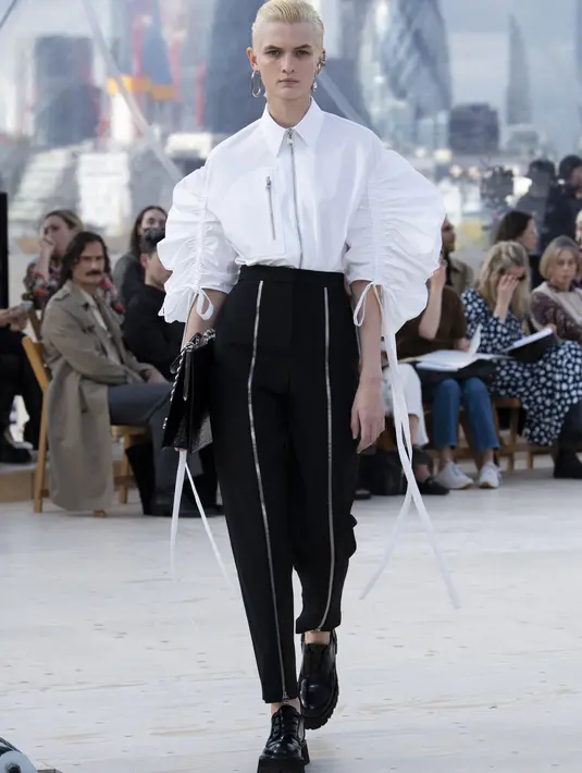 Kemeja katun poplin putih dengan detail ritsleting di tengah dan lengan parasut berlipit, dipadu dengan high-waisted peg trousers yang juga memiliki detail ritsleting sambung. Foto: Document/Alexander McQueen.