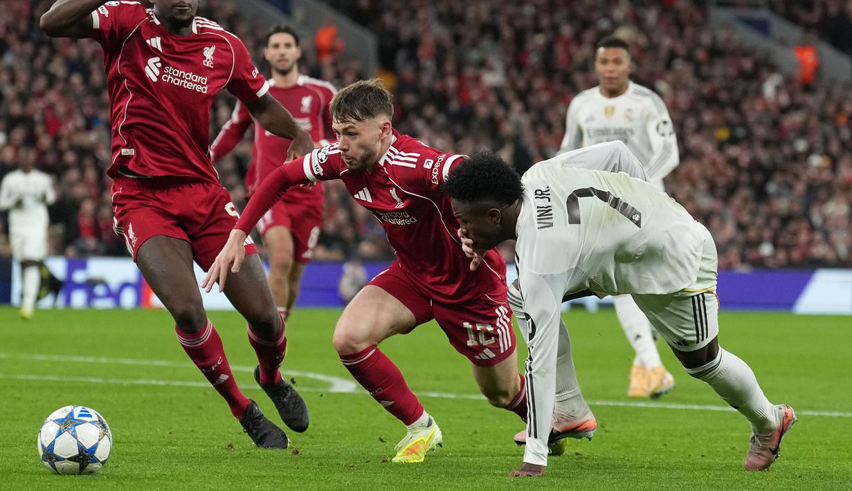 Pemain Liverpool, Conor Bradley (kiri) berebut bola dengan pemain Real Madrid, Vinicius Jr dalam laga Liga Champions 2025/2026 di Anfield, Liverpool, Inggris, Selasa (04/11/2025) waktu setempat. (AP Photo/Jon Super)