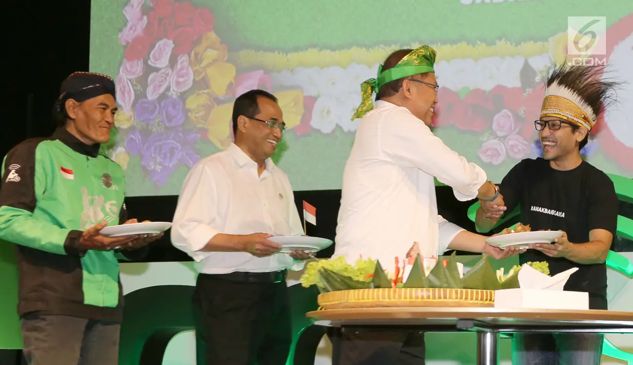 Menkominfo Rudiantara memberikan potongan tumpeng kepada CEO dan Founder Go-Jek Nadiem Makarim disaksikan Menhub Budi Karya Sumadi saat peluncuran layanan Go-Jek dari Sabang hingga Merauke di Jakarta, Rabu (15/8). (Liputan6.com/Fery Pradolo)