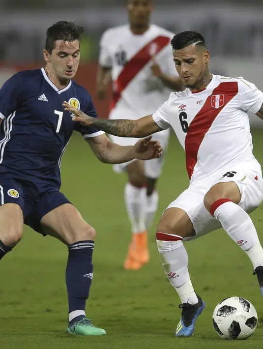 Pemain Peru, Miguel Trauco (kanan) berusaha mengecoh pemain Skotlandia, Kenny McLean pada laga uji coba di Lima, Peru, (29/5/2018). Peru menang 2-0. (AP/Martin Mejia)