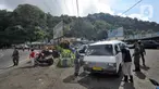 Petugas memeriksa kendaraan saat penyekatan arus lalu lintas di kawasan Ciloto, Cianjur, Jawa Barat, Jumat (17/4/2020). Pemkab Cianjur melakukan pengecekan suhu tubuh dan penyemprotan disinfektan di sejumlah titik keluar-masuk Cianjur untuk mencegah penyebaran COVID-19. (merdeka.com/Arie Basuki)
