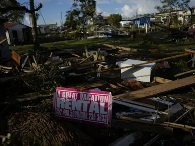 Sebuah tanda yang mengiklankan persewaan liburan terpasang pada sepotong kayu di tengah puing-puing yang berserakan dari rumah-rumah yang hancur dan usaha di Horseshoe Beach, Florida, satu hari setelah lewatnya Badai Idalia, Kamis (31/8/2023). (AP Photo/Rebecca Blackwell)