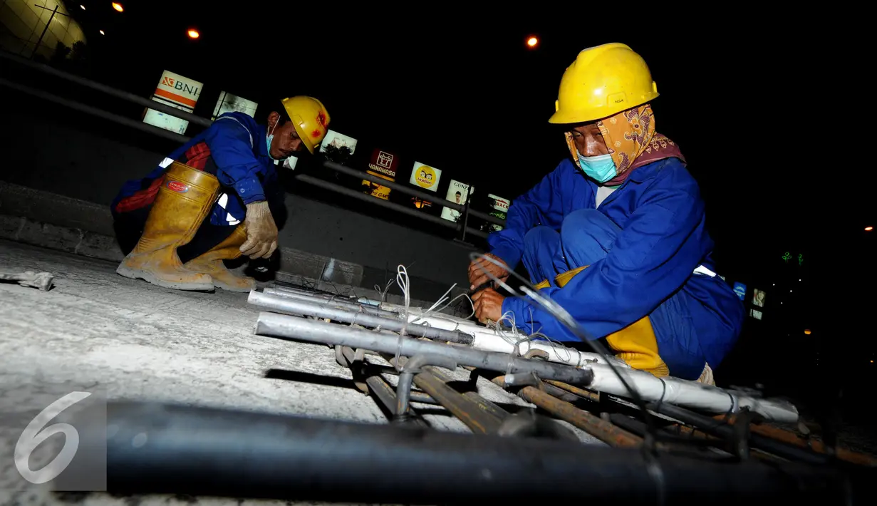 Pekerja saat merakit besi untuk perbaikan dan perawatan jalan 'Underpass' di kawasan Pondok Indah, Jakarta, Selasa (28/11). Perbaikan dan perawatan jalan tersebut guna mengantisipasi musim hujan. (Liputan6.com/Helmi Afandi)