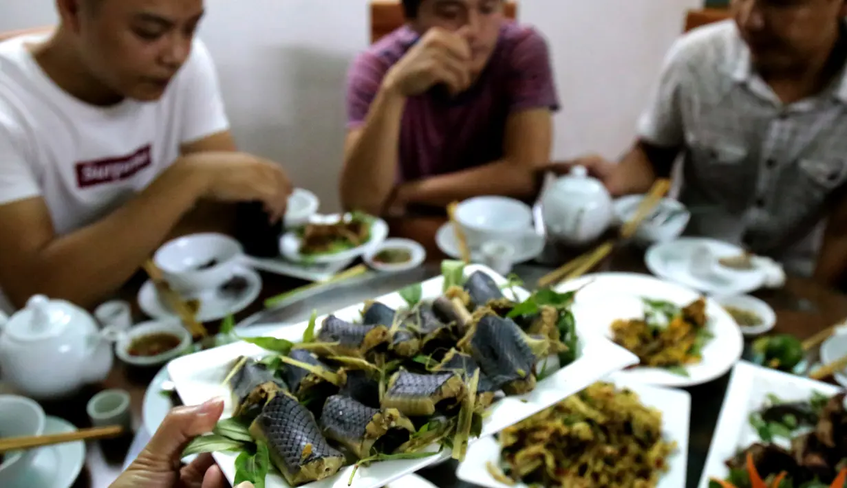 Foto pada 24 Agustus 2018, pelanggan menyantap olahan daging ular di restoran khusus provinsi Yen Bai. Meski daging ular menjadi kuliner favorit masyarakat Vietnam, ternyata tradisi ini disinyalir dapat mengganggu ekosistem di hutan. (AFP/Nhac NGUYEN)