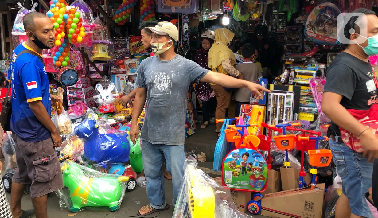 Warga memilih mainan tanpa menjaga jarak di Pasar Gembrong, Jakarta Timur, Minggu (31/5/2020). Meski penerapan masa Pembatasan Sosial Berskala Besar (PSBB) di Jakarta masih berlaku, namun pasar yang khusus menjual pernak-pernik mainan anak ini kembali dipadati warga. (Liputan6.com/Immanuel Antonius)