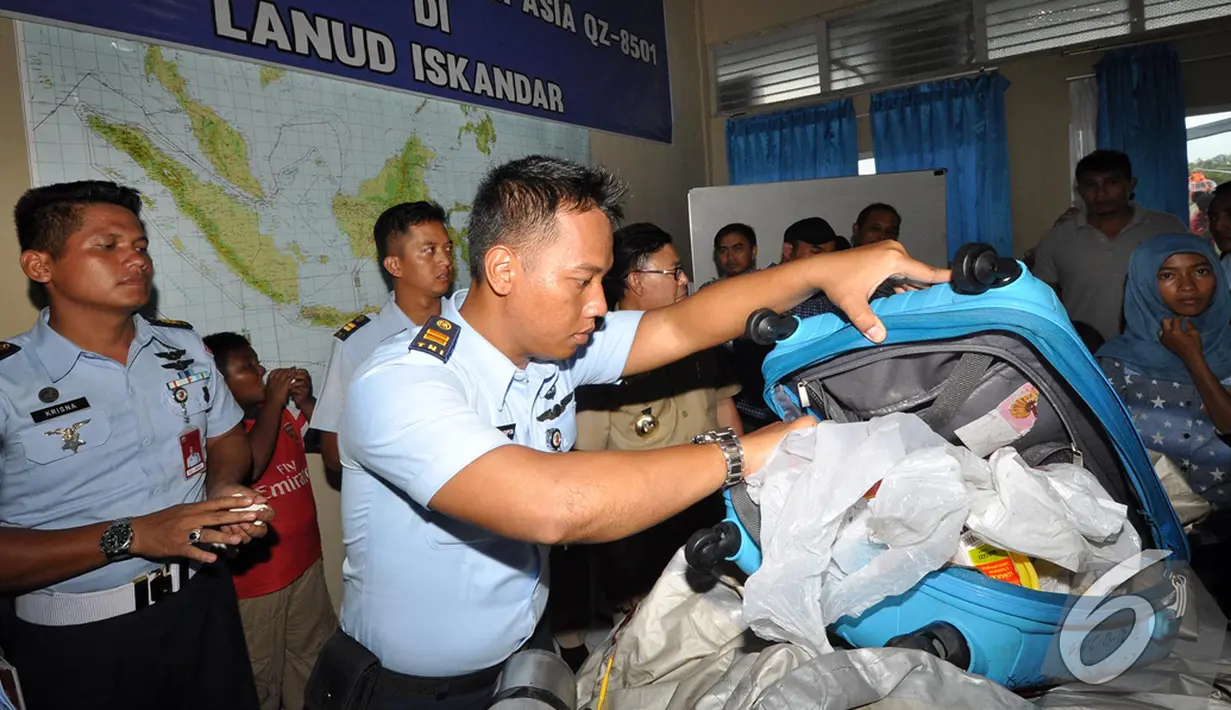 Salah satu anggota TNI AU memeriksa  barang yang diduga milik penumpang pesawat AirAsia QZ8501, Pangkalan Bun, Kalteng, Selasa (30/12/2014). (Liputan6.com/Miftahul Hayat)