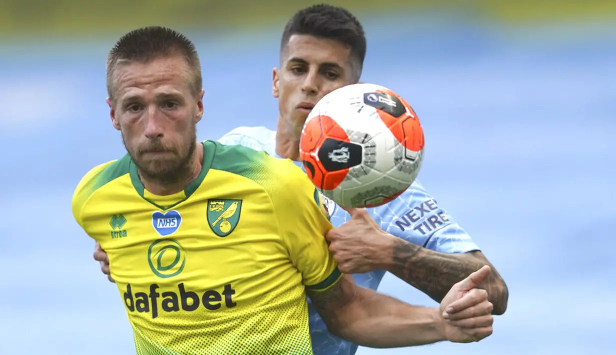Bek Manchester City, Joao Cancelo, berebut bola dengan pemain Norwich City, Marco Stiepermann, pada laga Premier League di Stadion Etihad, Minggu (26/7/2020). Manchester City menang dengan skor 5-0. (AP Photo/Dave Thompson, Pool)