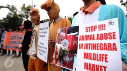 Aktivitis membentang poster saat melakukan aksi di depan Gedung Balai Kota, Jakarta, Kamis (13/10). Aktivitis beranggapan penutupan pasar satwa liar bisa mencegah kepunahan satwa. (Liputan6.com/Helmi Fithriansyah)