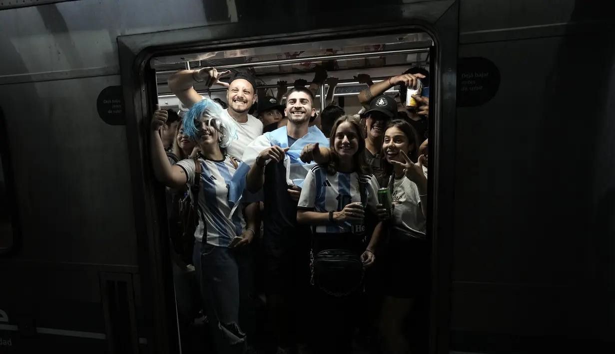 Para penggemar Argentina merayakan kemenangan atas Kroasia setelah menonton pertandingan semifinal Piala Dunia 2022 Qatar di TV mereka memasuki kereta bawah tanah di Buenos Aires, Argentina, Rabu (14/12/2022). (AP Photo/Rodrigo Abd)