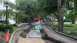 Pekerja melakukan perbaikan drainase dengan menggunakan alat berat di Kompleks Istana Kepresidenan, Jakarta, Senin (18/12). Pengerjaan rehabilitasi drainase kawasan istana kepresidenan ini guna mengantisipasi ancaman banjir. (Liputan6.com/Angga Yuniar)