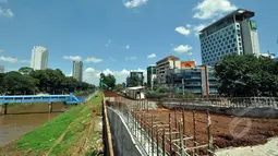Proyek pembangunan jalan inspeksi di Bantaran Kanal Banjir Barat kawasan Thamrin, Jakarta, Selasa (17/3/2015). Pembangunan jalan yang diproyeksikan untuk jalur alternatif bagi warga ini diperkirakan rampung pertengahan 2015. (Liputan6.com/Faizal Fanani)