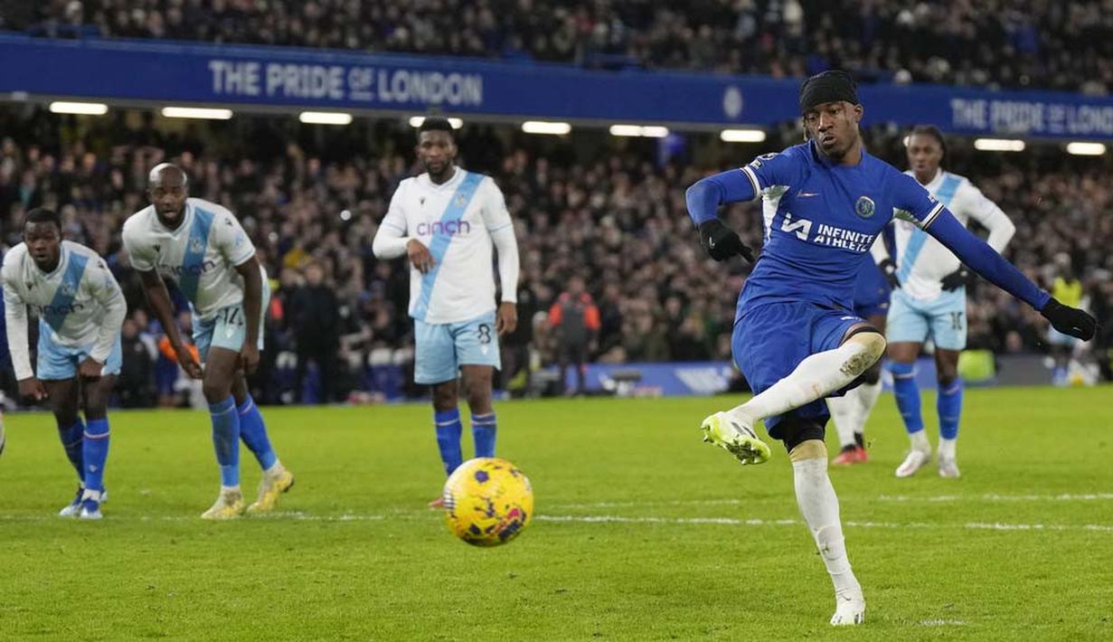 Pemain Chelsea, Noni Madueke, mencetak gol melalui tendangan penalti saat melawan Crystal Palace pada pekan ke-19 Premier League 2023/2024 di Stadion Stamford Bridge, Kamis (28/12/2023). The Blues menang dengan skor tipis 2-1. (AP Photo/Alastair Grant)