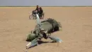 Dua pria yang mengendarai motor melewati reruntuhan helikopter Rusia yang ditembak jatuh di wilayah Idlib, Suriah, Senin (1/8). Menurut laporan, helikopter itu dalam perjalanan kembali setelah membawa bantuan kemanusiaan ke Aleppo. (Mohamed al-Bakour/AFP)