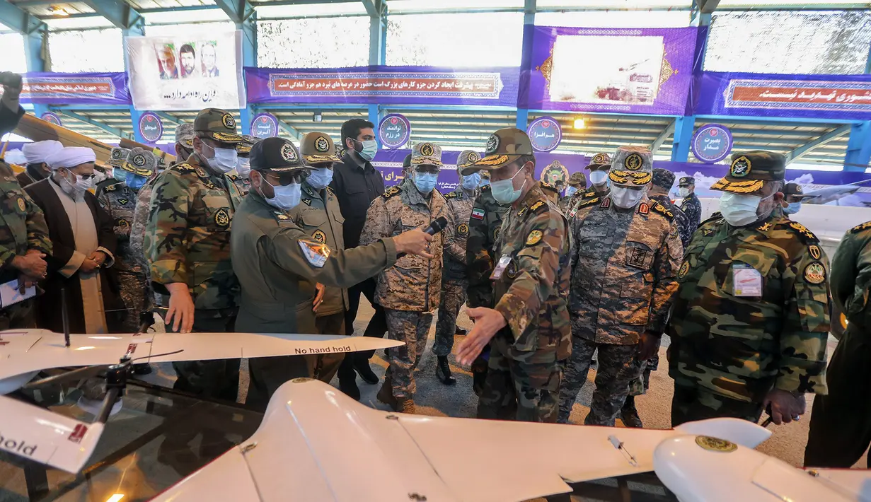 Kepala Staf Umum Angkatan Bersenjata Jenderal Mohammad Hossein Bagheri (tengah) mendengarkan penjelasan saat mengunjungi tampilan drone sebelum latihan di Iran (5/1/2021). (Iranian Army via AP)