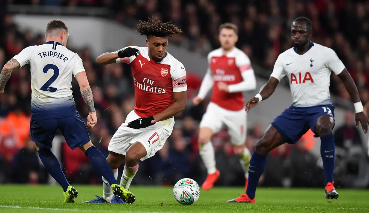 Striker Arsenal, Alex Iwobi, berusaha melewati bek Tottenham, Kieran Trippier, pada laga perempat final Piala Liga di Stadion Emirates, London, Rabu (19/12). Arsenal kalah 0-2 dari Tottenham. (AFP/Ben Stansall)