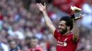 Penyerang Liverpool, Mohamed Salah, mengangkat trofi Sepatu Emas Premier League usai laga melawan Brighton & Hove Albion di Stadion Anfield, Minggu (13/5/2018). Salah menjadi top scorer Premier League dengan raihan 32 gol. (AP/Dave Thompson)