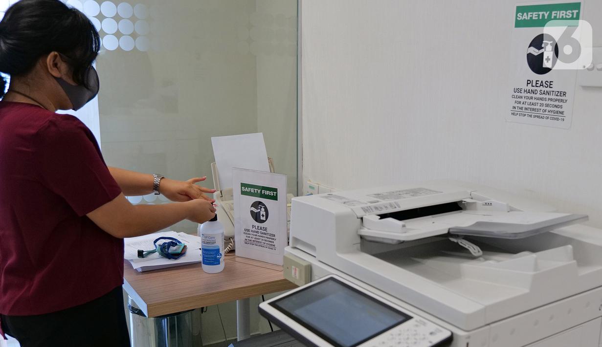 Karyawan menggunakan cairan pembersih tangan setelah menggunakan mesin fotokopi di ruang kantor Suntory Garuda, Jakarta, Senin (8/8/2020). Suntory Garuda menerapkan protokol Kesehatan, salah satunya kapasitas karyawan hanya dibolehkan sebanyak 50 persen. (Liputan6.com/Herman Zakharia)