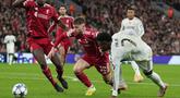 Pemain Liverpool, Conor Bradley (kiri) berebut bola dengan pemain Real Madrid, Vinicius Jr dalam laga Liga Champions 2025/2026 di Anfield, Liverpool, Inggris, Selasa (04/11/2025) waktu setempat. (AP Photo/Jon Super)