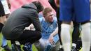 Gelandang Manchester City, Kevin De Bruyne mendapat perawatan dari tim medis usai mengalami cedera saat menghadapi Chelsea dalam laga semifinal Piala FA 2020/2021 di Wembley Stadium, London, Sabtu (17/4/2021). Manchester City kalah 0-1 dari Chelsea. (AFP/Ian Walton/Pool)