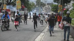 Para pengunjuk rasa dibubarkan oleh gas air mata yang dilemparkan oleh polisi selama demonstrasi menuntut Perdana Menteri Haiti Ariel Henry mundur dan menyerukan kualitas hidup yang lebih baik, di Port-au-Prince, Haiti, Senin (29/8/2022). (AP Photo/Odelyn Joseph)