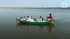Sejumlah murid berangkat ke sekolah naik perahu melewati rob di Kampung Timbulsloko, Demak, Jawa Tengah, Rabu (24/5/2023). Para murid terpaksa mendayung sekitar satu kilometer menuju daratan terdekat ke sekolah akibat sudah sekitar tujuh tahun kampung mereka dikelilingi air laut karena krisis iklim dan penurunan muka tanah. (merdeka.com/Arie Basuki)