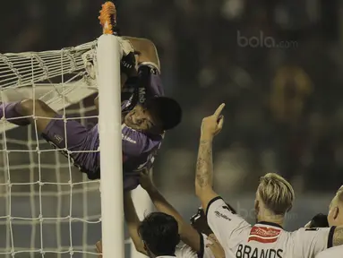 Kiper Bali United, Wawan Hendrawan, melakukan selebrasi panjat tiang gawang usai mengalahkan Madura United pada laga Piala Presiden di Stadion Manahan, Solo, Sabtu, (3/2/2018). Bali United menang adu penalti dengan skor 5-4. (Bola.com/M Iqbal Ichsan)