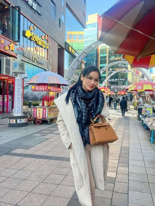 Penampilan ketiga, Titi Kamal tampil simple dengan top hitam, wool coat, long pants coklat, dan scarf hitam. [@titi_kamall]
