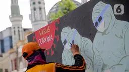 Petugas PPSU Kelurahan Bukit Duri menyelesaikan mural bertema Covid-19 di Jakarta, Selasa (11/8/2020). Mural tersebut untuk mengingatkan warga agar selalu waspada dengan Covid-19 dan mencegahnya dengan 3M (Memakai Masker, Menjaga Jarak dan Mencuci Tangan). (Liputan6.com/Faizal Fanani)