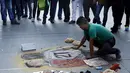 Seniman Chili melukis tindakan provokasi Gonzalo Jara terhadap pemain Uruguay, Edinson Cavani di trotoar jalan di Santiago, Chili (28/6/2015). Jara gagal memperkuat Chili di sisa turnamen Piala Amerika yang lolos ke semifinal. (REUTERS/Marcos Brindicci)