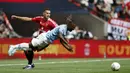 Gelandang Manchester City, Jeremy Doku (kanan) terjatuh saat perebutan bola dengan bek Manchester United, Diogo Dalot pada laga Community Shield 2024 di Wembley Stadium, London, Sabtu (10/8/2024). (AP Photo/David Cliff)