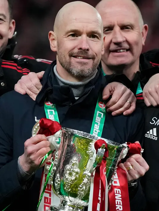 Pelatih Kepala Manchester United, Erik Ten Hag berpose dengan trofi setelah pertandingan sepak bola final Piala Liga Inggris antara Manchester United dan Newcastle United di Stadion Wembley di London, Minggu, 26 Februari 2023. Gelar Piala Liga Inggris ini juga jadi sumbangsih perdana manajer Erik ten Hag sejak bergabung ke Old Trafford musim panas 2022. (AP Photo/Alastair Grant)