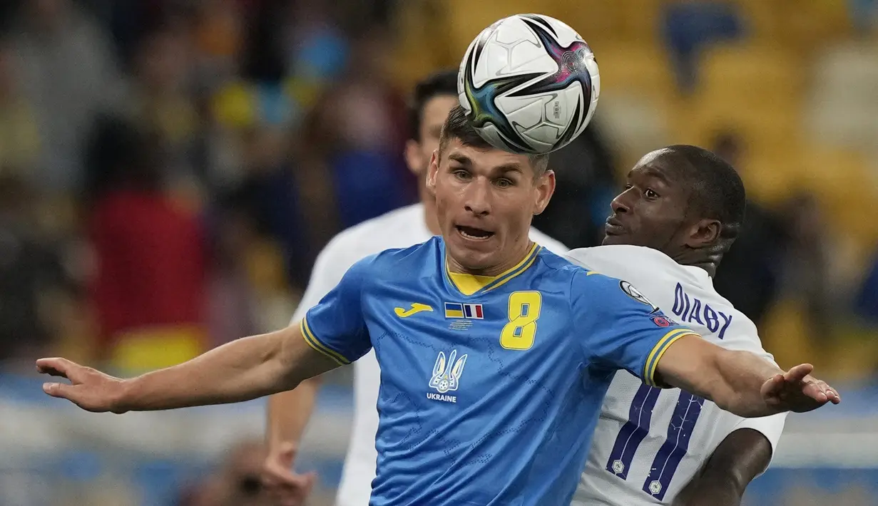 Gelandang timnas Ukraina Ruslan Malinovsyi berebut bola dengan penyerang timnas Prancis, Moussa Diaby dalam laga Kualifikasi Piala Dunia 2022 zona Eropa di NSK Olimpiyskiy, Minggu (5/9/2021) dinihari WIB. Prancis bermain imbang 1-1 dengan tuan rumah, Ukraina. (AP Photo/Efrem Lukatsky)