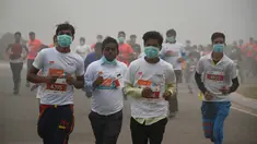 Peserta lari New Delhi 10K menggunakan masker tetap mengikuti lomba ditengah-tengah kabut polusi yang menimpa kota New Delhi, India (6/11). Kabut asap ini diklaim sebagai kabut terparah yang dialami oleh New Delhi dalam 17 tahun. (AFP/Dominique Faget)