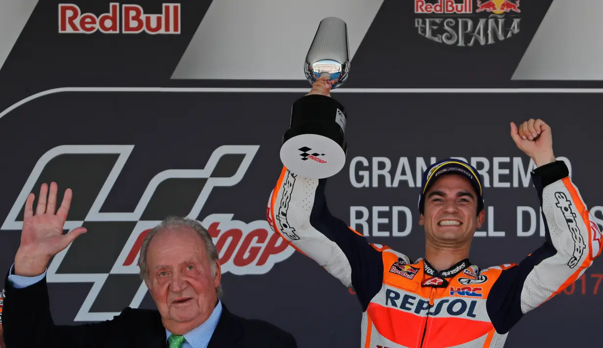 Pembalap Repsol Honda, Dani Pedrosa memegang trofi saat merayakan kemenangannya (kanan) pada balapan MotoGP Spanyol di Sirkuit Jerez, Minggu (7/5). Pedrosa finish terdepan dengan catatan waktu 45 menit 26,827 detik. (AP Photo/Miguel Morenatti)