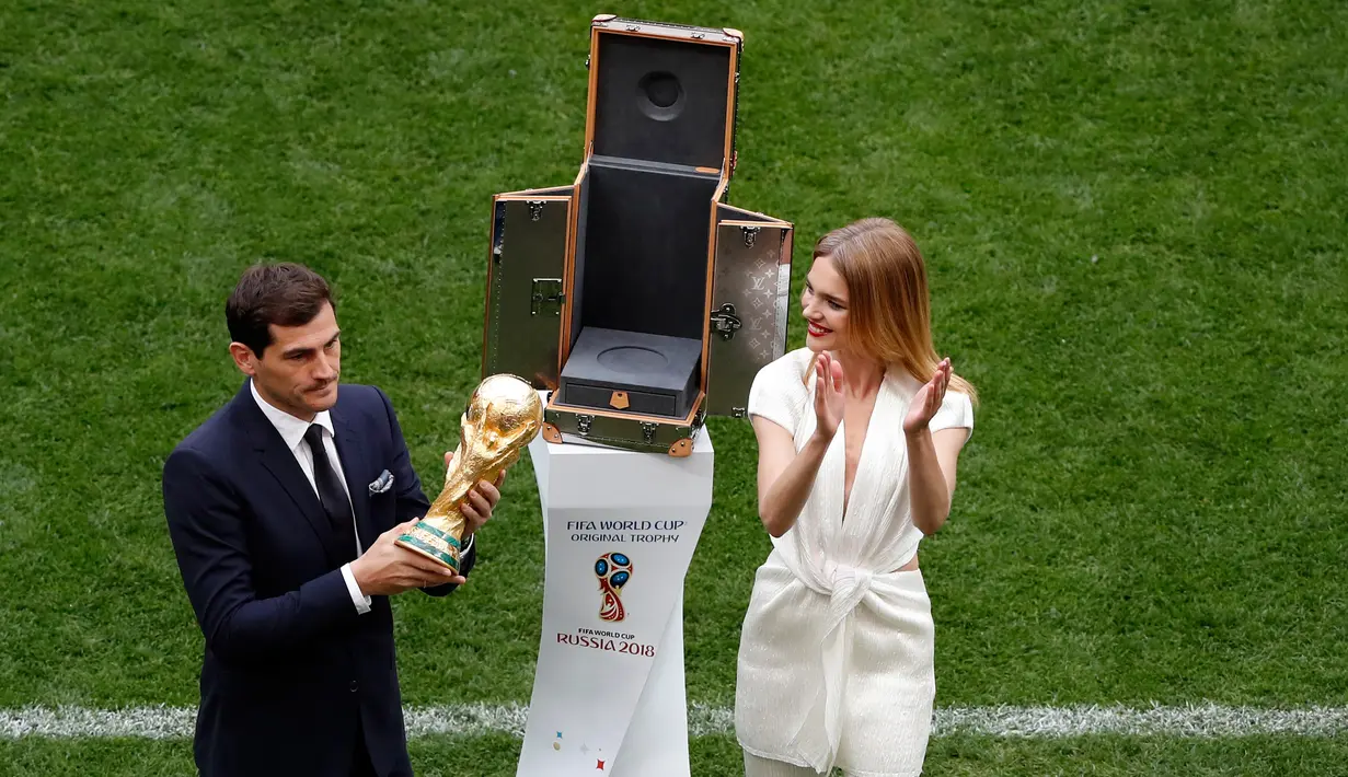 Mantan kiper timnas Spanyol, Iker Casillas didampingi supermodel Rusia,  Natalia Vodianova memamerkan trofi Piala Dunia 2018 sebelum laga pembuka di stadion Luzhniki, Moskow, Kamis (14/6). Trofi Piala Dunia itu terbuat dari emas 18 karat (AP/Darko Bandic)