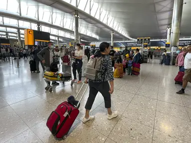 Wisatawan memadati bandara Heathrow, di London,  Rabu (13/7/2022). Bandara tersibuk di Inggris itu telah memberlakukan pembatasan jumlah penumpang saat periode libur musim panas ini karena sektor penerbangan berjuang untuk mengatasi lonjakan permintaan perjalanan.  (AP Photo/Alberto Pezzali)