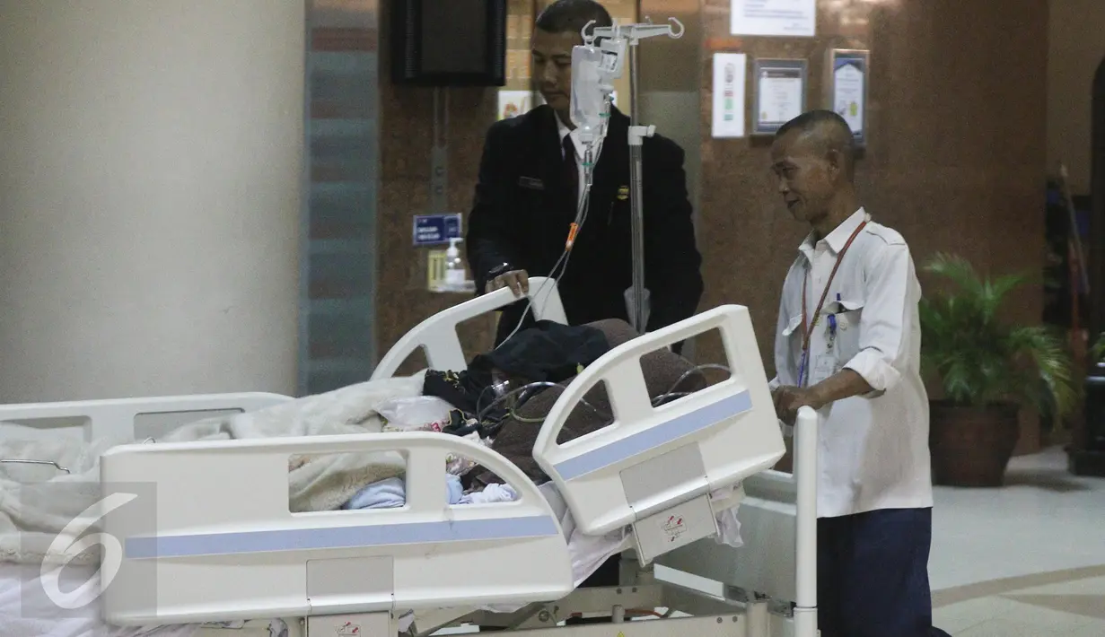 Petugas membawa Julia Perez alias Jupe ke ruang perawatan usai menjalani cuci darah di RSCM, Jakarta (21/4). Pelantun lagu Belah Duren tersebut terlihat terbaring lemah dengan kondisi kepala tertutup kain hitam. (Liputan6.com/Herman Zakharia)